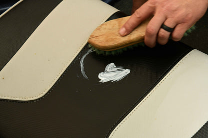 Using a brush to apply Vinyl Conditioner on a boat seat